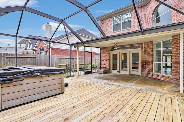 wooden terrace with a hot tub, fence, and a ceiling fan