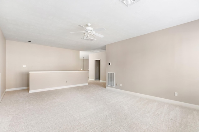 spare room with visible vents, a ceiling fan, and light carpet