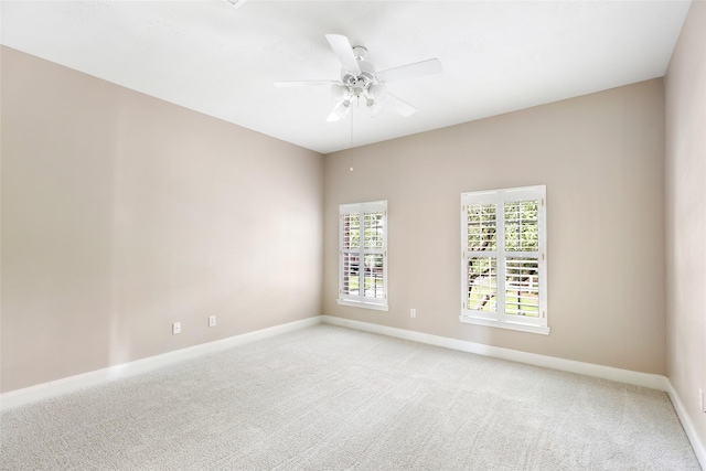 unfurnished room with baseboards, light carpet, and a ceiling fan