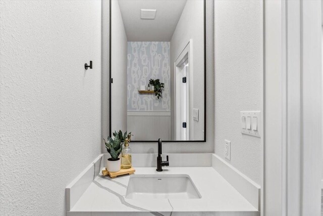bathroom with vanity and a textured wall