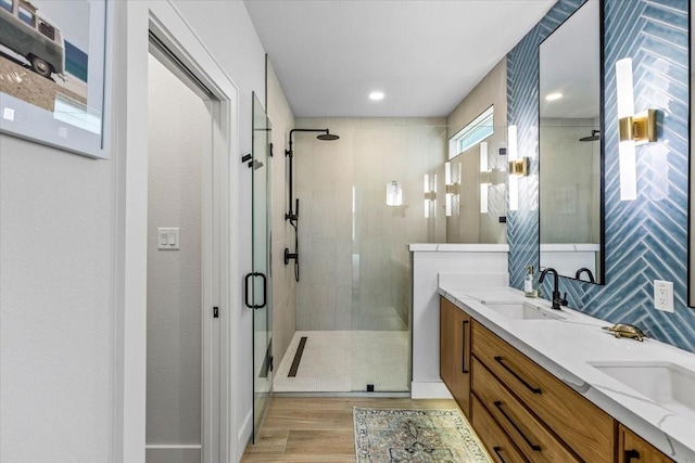 bathroom with a sink, a shower stall, and wood finished floors