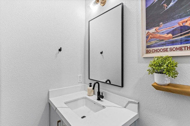 bathroom with vanity and a textured wall