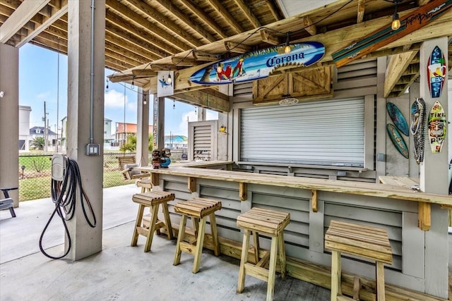 view of patio with fence and outdoor dry bar
