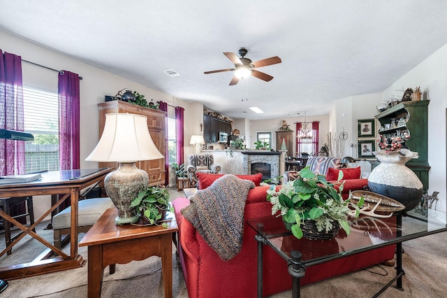 carpeted living room with a ceiling fan, a fireplace, and visible vents