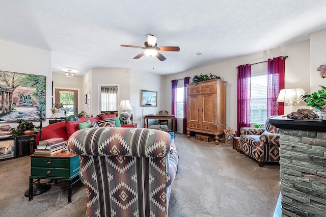 living room featuring visible vents, ceiling fan, and carpet
