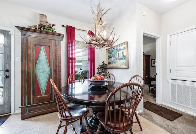 dining room featuring an inviting chandelier, light tile patterned floors, visible vents, and baseboards