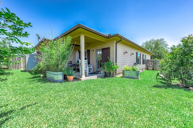 rear view of property with a yard, fence, and a patio