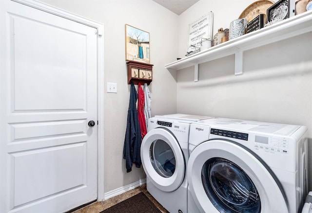washroom with baseboards, laundry area, and washer and clothes dryer