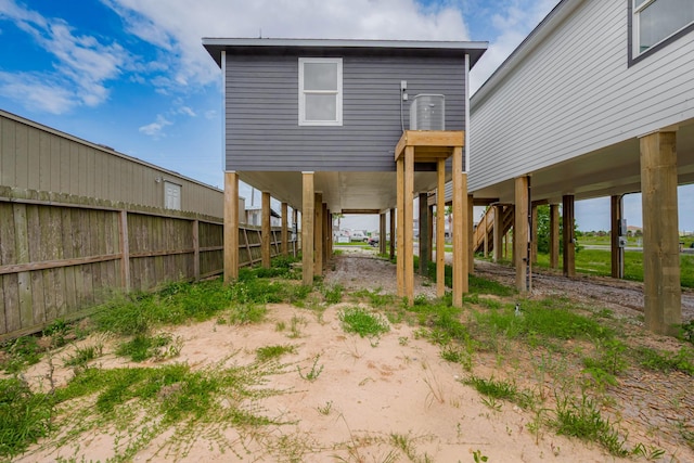 back of property featuring stairs, fence, and a carport