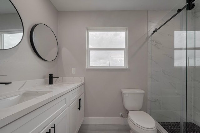 full bath with toilet, baseboards, a sink, and a shower stall