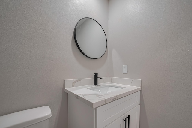 half bathroom with toilet and vanity