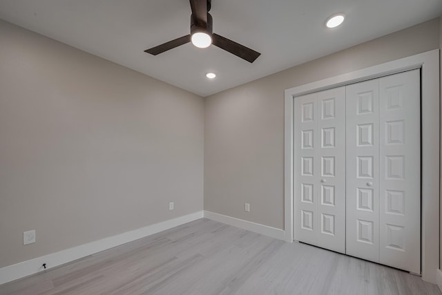 unfurnished bedroom with baseboards, a closet, light wood finished floors, and recessed lighting