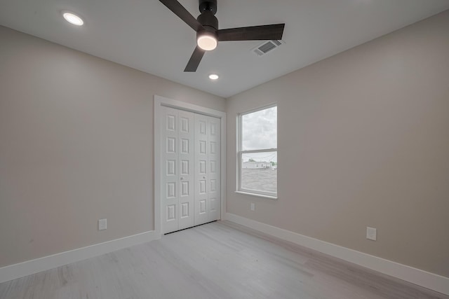 unfurnished bedroom with a closet, visible vents, light wood finished floors, ceiling fan, and baseboards