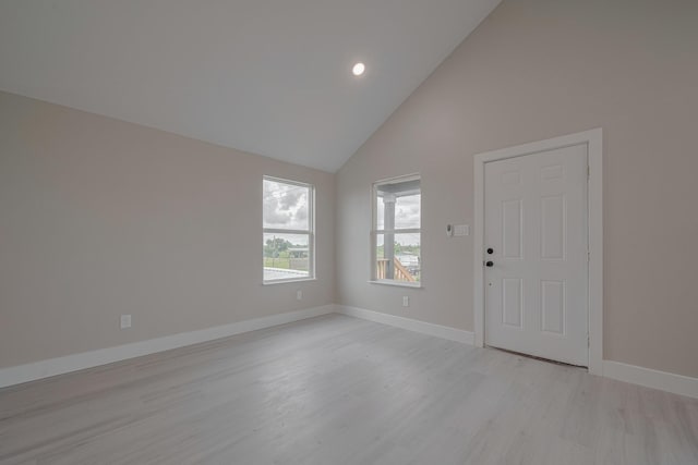 spare room featuring baseboards, recessed lighting, light wood-type flooring, and high vaulted ceiling