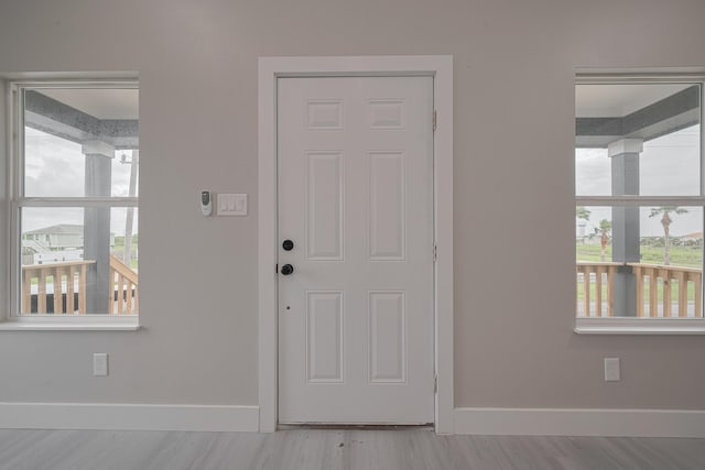 foyer entrance with wood finished floors and baseboards