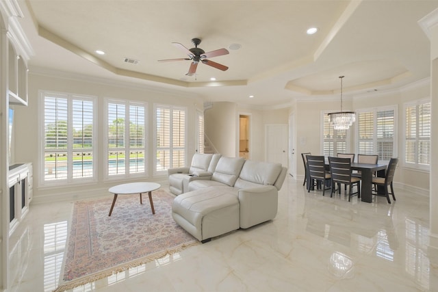 living room featuring a tray ceiling, visible vents, ceiling fan with notable chandelier, and a healthy amount of sunlight
