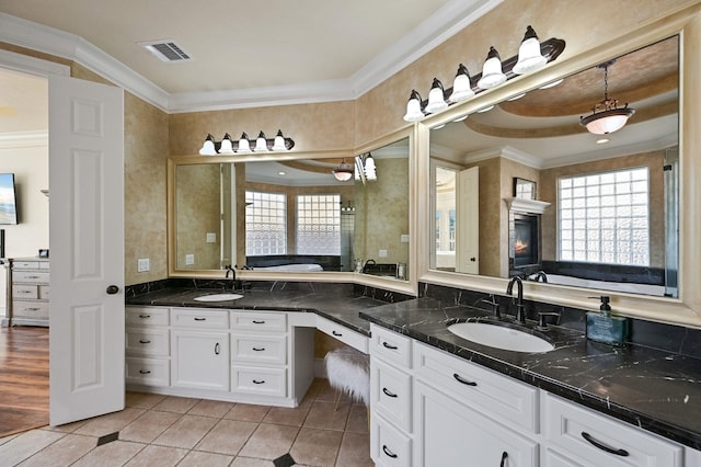 full bathroom featuring a wealth of natural light, ornamental molding, and a sink