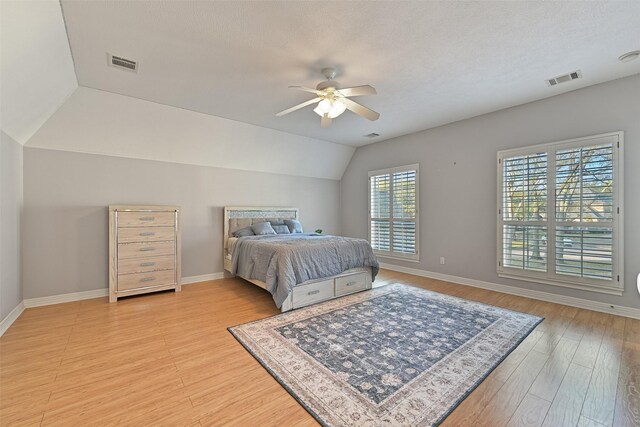 bedroom with baseboards, light wood finished floors, and visible vents