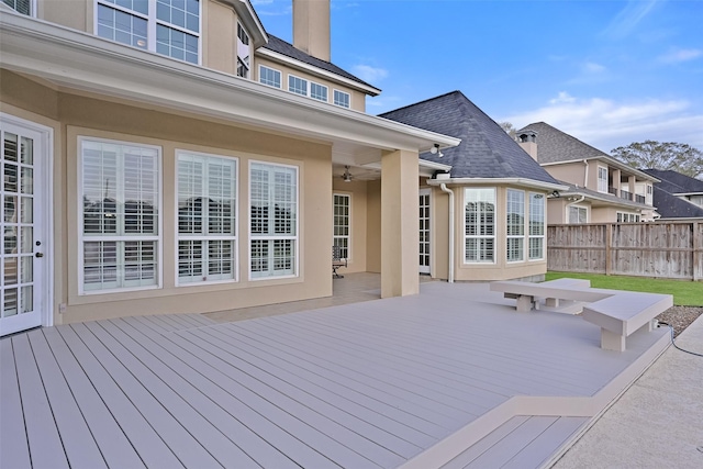 wooden deck with ceiling fan and fence