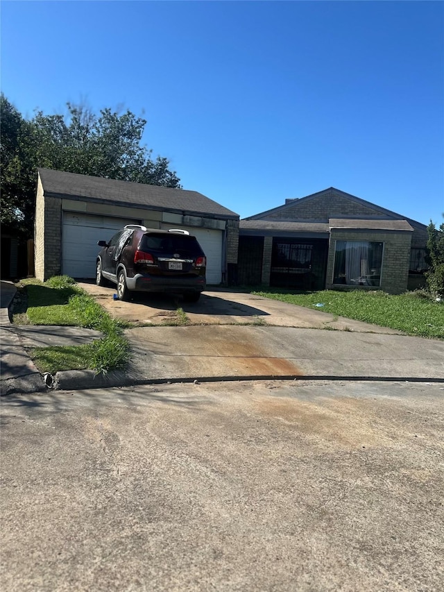 ranch-style house with concrete driveway, an attached garage, and brick siding