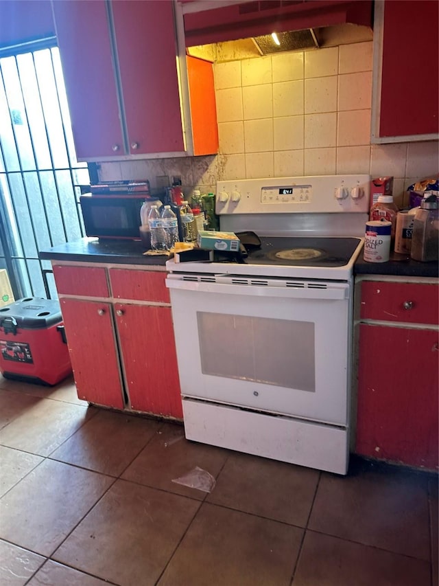 kitchen featuring red cabinets, tile patterned floors, white electric stove, and decorative backsplash