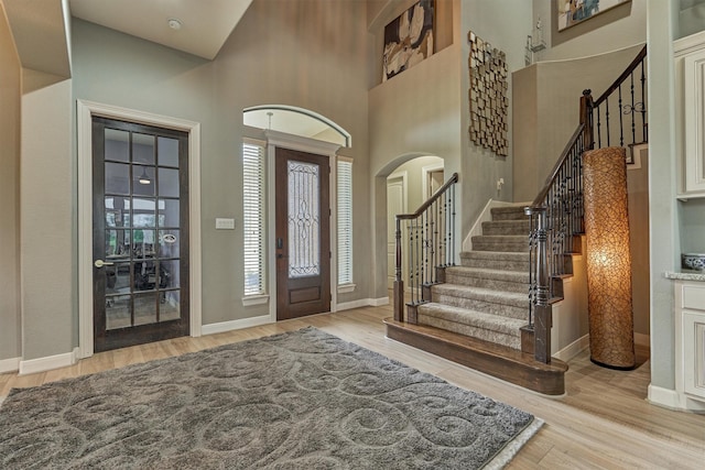 18787 Serene Water Dr, Montgomery, TX 77356 - foyer entrance with arched walkways, light wood-style floors, baseboards, and stairway