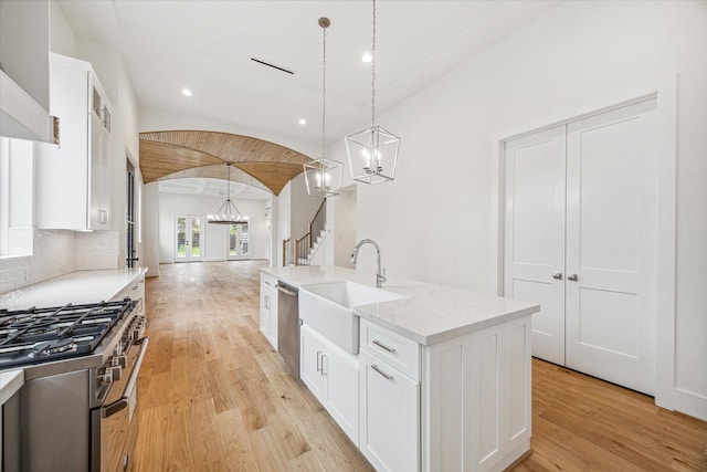 519 W 27th St, Houston, TX 77008 - kitchen with a sink, lofted ceiling, a chandelier, light wood-style flooring, and appliances with stainless steel finishes