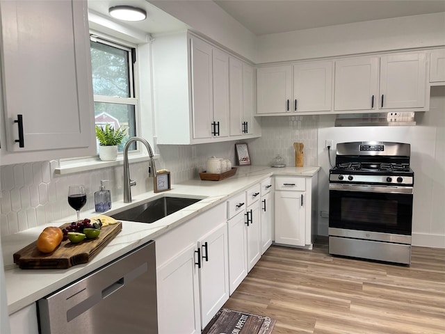 1107 Dover Cir, Alvin, TX 77511 - kitchen featuring appliances with stainless steel finishes, a sink, white cabinetry, and backsplash