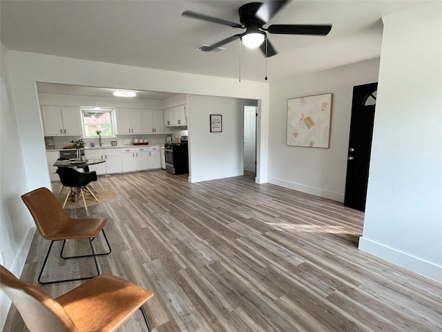 1107 Dover Cir, Alvin, TX 77511 - living area with a ceiling fan, light wood-style floors, and baseboards