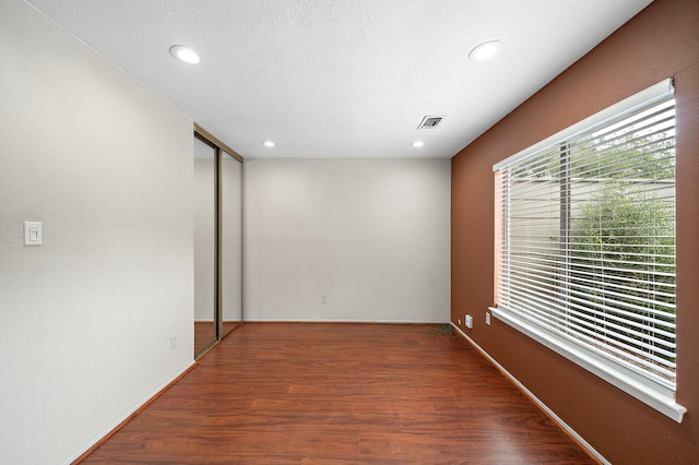 empty room with recessed lighting, visible vents, and wood finished floors