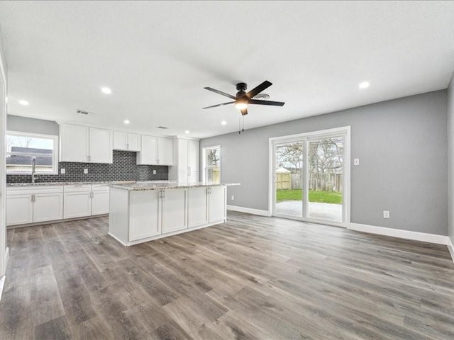 kitchen featuring a kitchen island, baseboards, a ceiling fan, and recessed lighting