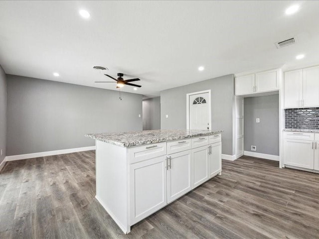 kitchen featuring dark wood-style flooring, recessed lighting, visible vents, and a center island