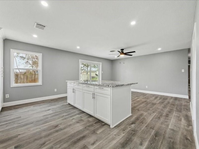 kitchen with a ceiling fan, visible vents, white cabinetry, open floor plan, and wood finished floors