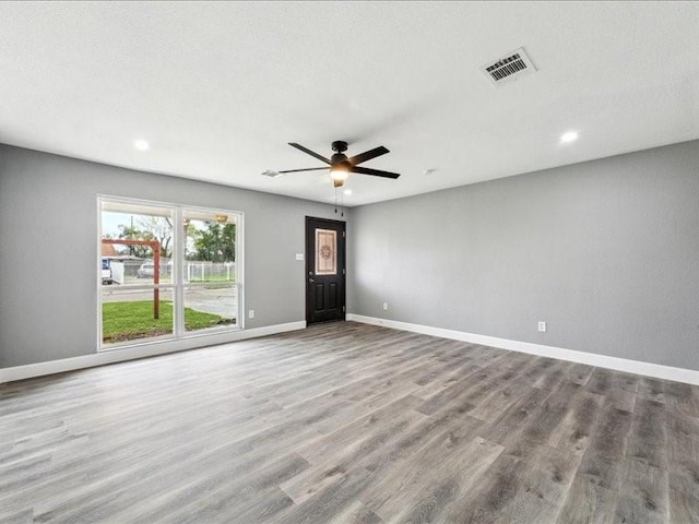 spare room with baseboards, recessed lighting, visible vents, and wood finished floors