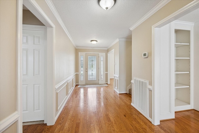 1415 Stependale Dr, Katy, TX 77450 - entryway with light wood-style floors, crown molding, visible vents, and a textured ceiling