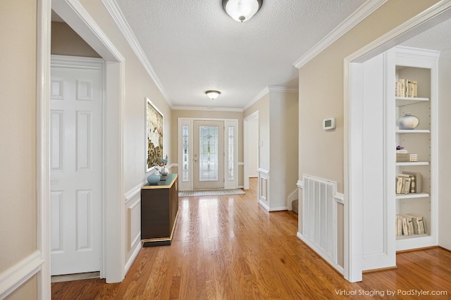 1415 Stependale Dr, Katy, TX 77450 - entryway featuring crown molding, light wood-style floors, visible vents, and a textured ceiling