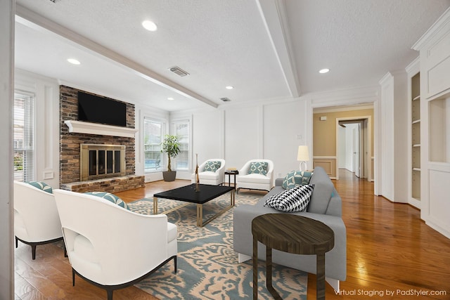 1415 Stependale Dr, Katy, TX 77450 - living room with a decorative wall, beam ceiling, a textured ceiling, and wood finished floors