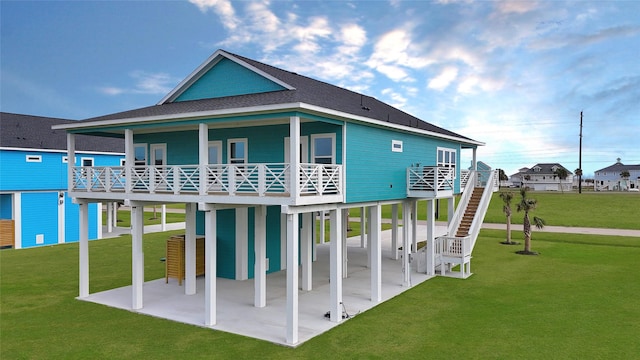rear view of house featuring a patio, a yard, and a carport