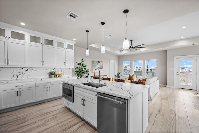 kitchen featuring stainless steel appliances, a sink, recessed lighting, light wood-style floors, and white cabinetry