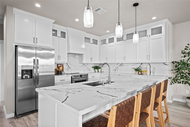 kitchen featuring stainless steel appliances, a sink, custom exhaust hood, recessed lighting, and backsplash