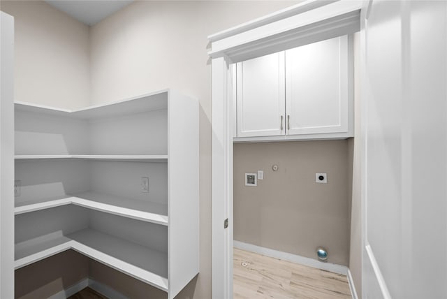laundry room featuring hookup for an electric dryer, light wood finished floors, cabinet space, baseboards, and hookup for a washing machine
