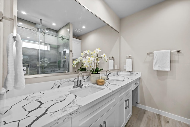 full bathroom with a stall shower, double vanity, recessed lighting, wood finished floors, and baseboards