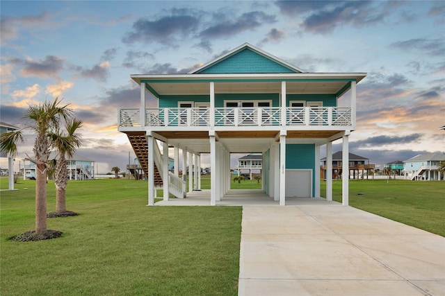 view of front facade featuring a carport, an attached garage, a lawn, and concrete driveway