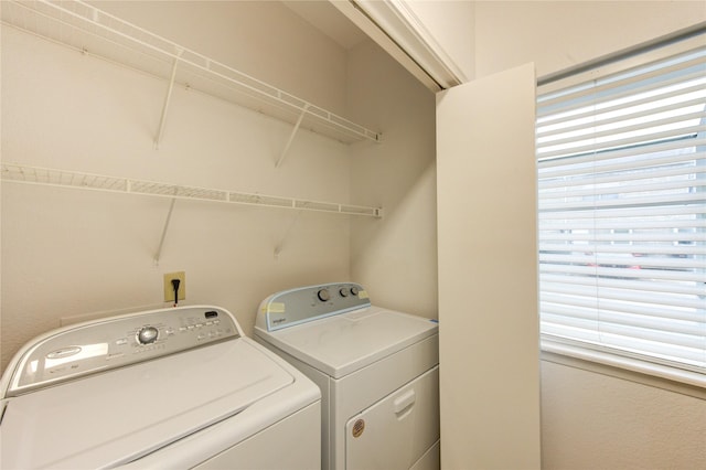 laundry area featuring washing machine and dryer, a healthy amount of sunlight, and laundry area