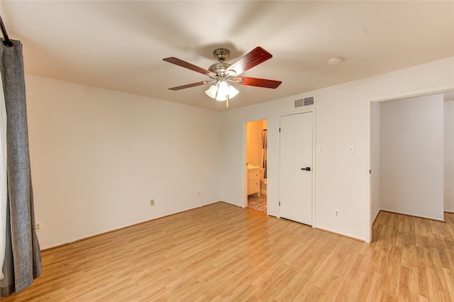 unfurnished room with light wood-style floors, visible vents, and a ceiling fan