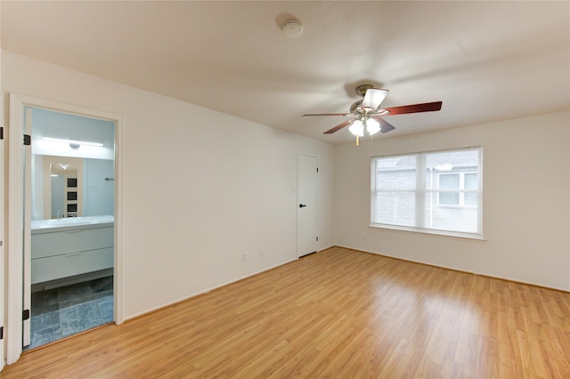 empty room featuring light wood finished floors and a ceiling fan