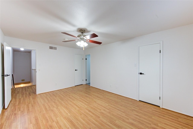 empty room featuring ceiling fan, visible vents, and light wood-style floors