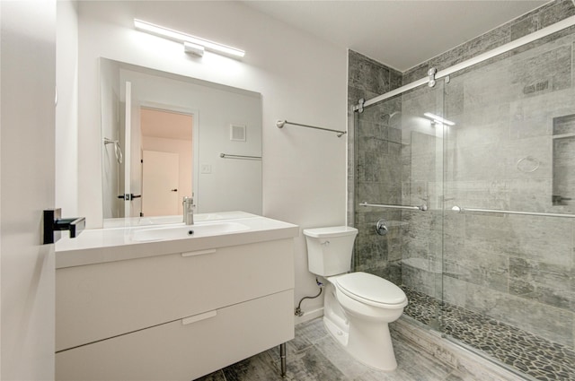 bathroom featuring vanity, toilet, a shower stall, and visible vents