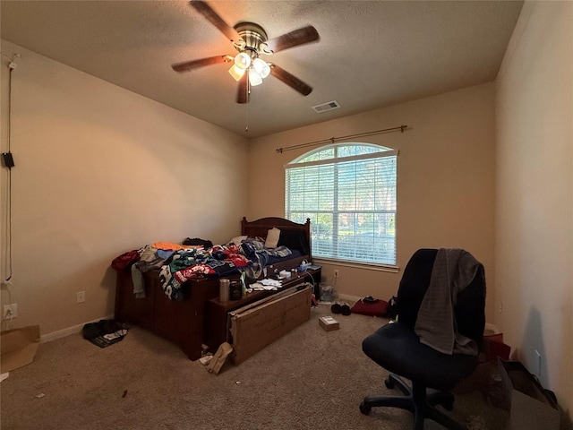 carpeted bedroom with ceiling fan, a textured ceiling, baseboards, and visible vents