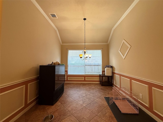 interior space featuring a decorative wall, a wainscoted wall, ornamental molding, visible vents, and a chandelier